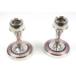 Pair of Arts and Crafts silver candlesticks, each with a tapering cylindrical column, on a