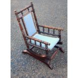 Edwardian American style child's stained beech rocking armchair, with a turned frame and upholstered