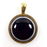 Circular singular bullseye agate pendant set in a gold coloured beaded bezel mount.