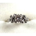 White metal ring, with a diamond, 0.75 carat approx. in a floral setting, size K, stamped 18ct., 3.4