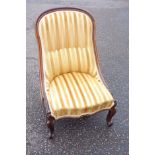 Victorian carved rosewood nursing chair with an arched back and serpentine seat, upholstered in