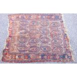 Persian rug, the madder ground with 4 rows of hooked medallions and all over stylised floral