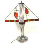 Tiffany style table lamp with a silvered metal and red enamel baluster column, on a circular foot,