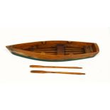 Stained pine model of a rowing boat with a pair of oars, L.53.6cm, (lacking 4 rollocks)