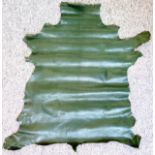Whole goat skin, dyed dark green, some blemishes, 88 x 85cm at widest points; and a red half skin,