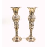 Pair of Edwardian silver vases with wavy flared rim and all round floral repousse decoration, on a