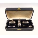 George V silver cruet set comprising pepperette, salt and mustard pot, both with blue glass