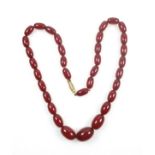 Cherry amber bakelite necklace with 34 graduated oval beads and barrel clasp, L.50.5cm, gross 27.