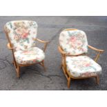 Two Ercol beech spindle back open armchairs of slightly differing sizes on turned tapering legs (one