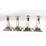 Pair of late Victorian silver candlesticks, each with a circular column decorated with ribbons and