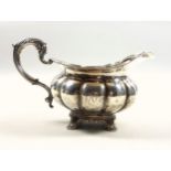 William IV silver milk jug of round lobed form with a reeded scalloped rim and twin scroll handle,