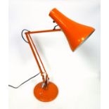 Orange anglepoise lamp on a circular base