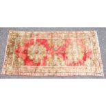 Persian rug, the madder field with 2 floral medallions and spandrels surrounded by floral borders