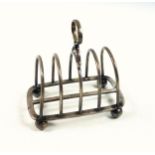 Edwardian silver toast rack with 5 hoop bars, on 4 ball feet, by Goldsmiths and Silversmiths Co.,