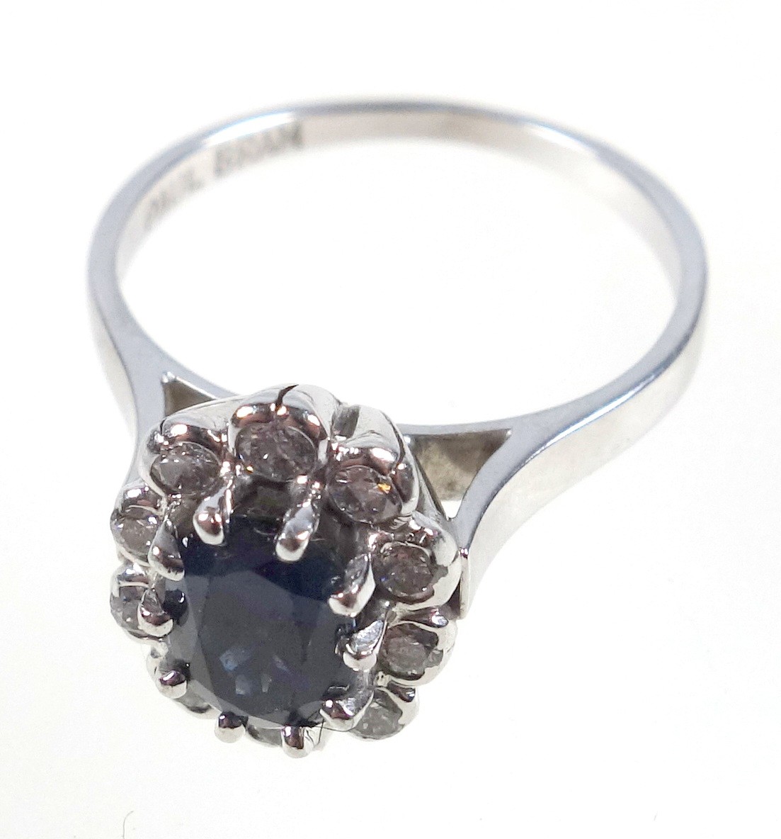 White metal ring set oval sapphire and 10 diamonds, stamped 750, 3.9grs
