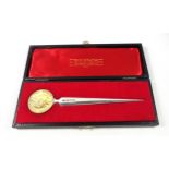 Elizabeth II silver paper knife with a tapering blade, the terminal set with a medal commemorating