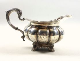 William IV silver milk jug of round lobed form with a reeded scalloped rim and twin scroll handle,
