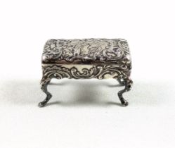 Novelty silver table top pinch or pill box in the form of a piano stool with all over rococo