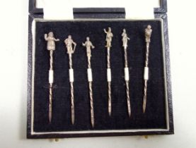 Set of 6 novelty silver cocktail sticks, each with with a twisted stem and finial in the form of a