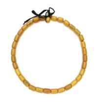 A STRAND OF AMBER OVAL BEADS