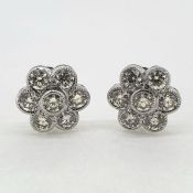 White gold Daisy diamond cluster earrings. Seven round brilliant cut diamonds in bezel settings.
