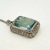 Emerald cut aquamarine in a diamond framed pendant with diamond bale suspended on a 18 carat white