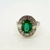 18 carat white gold emerald and diamond cluster ring. A nice bright oval emerald set with 4 gold