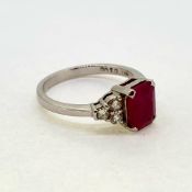 An emerald cut ruby ring with diamond shoulders. Hallmarked 750