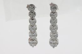 Six white metal pave set graduating hearts make up this diamond drop earring pair. Just under 3cm in