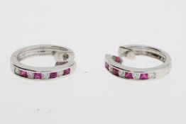 White metal hinged hoop earrings set with ruby and diamond. Marked D020 R042 K18