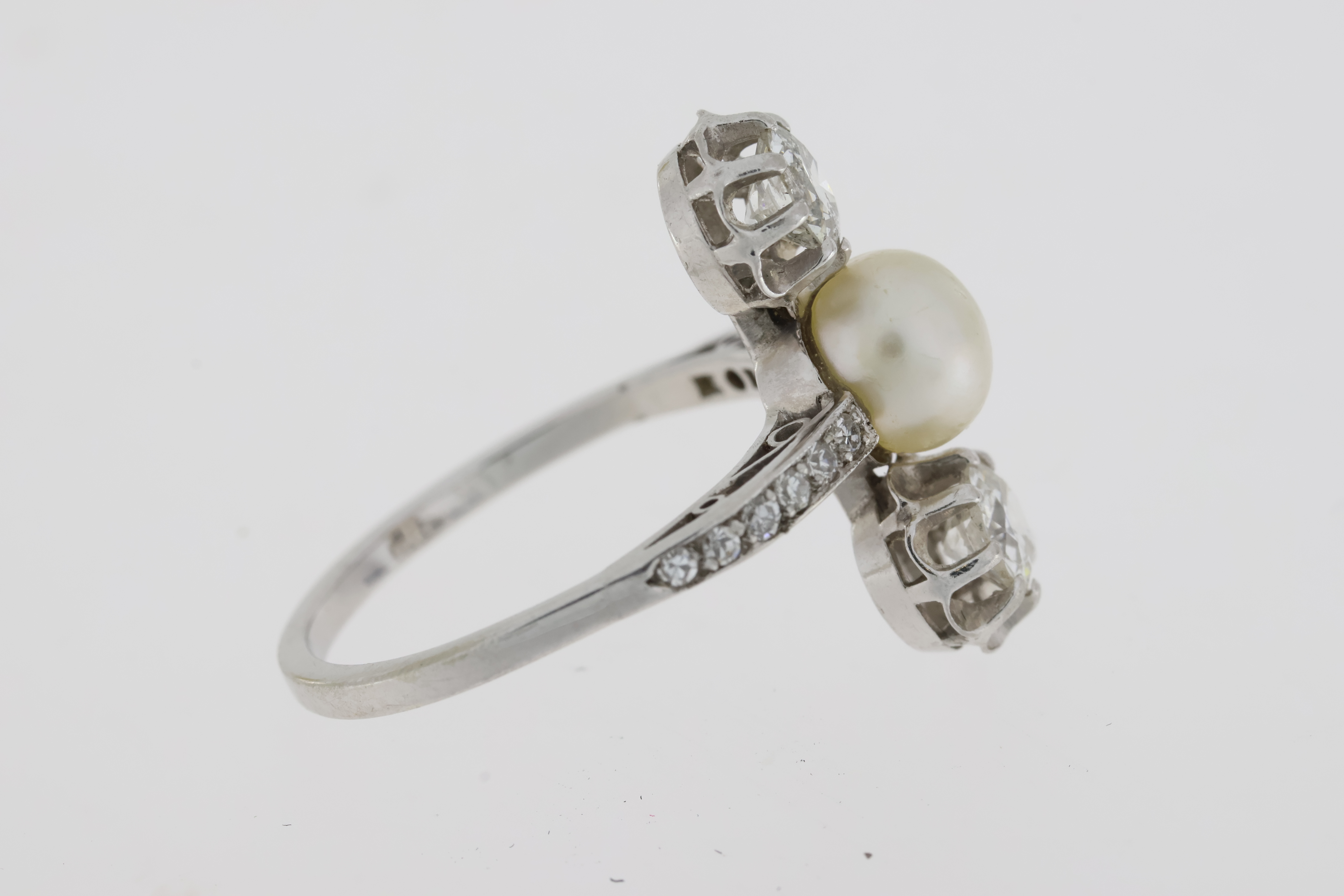 An art deco platinum trilogy ring comprising anatural pearl set between two old cut diamonds. - Image 3 of 3