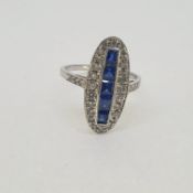White gold oval shaped ring with a central row of step cut sapphires 18ct