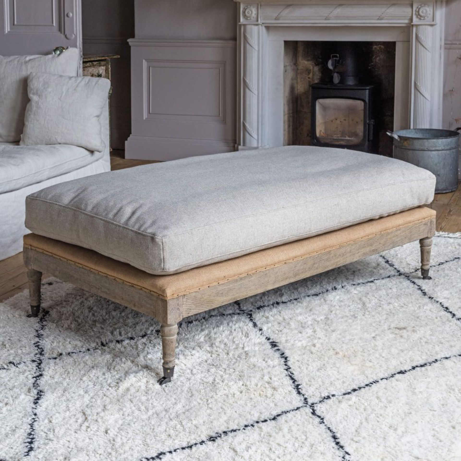 DUKE NATURAL LINEN OTTOMAN. RRP £745.00 - SR5. A long rectangular ottoman with carved oak wooden