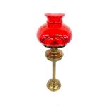 Vintage cranberry and brass oil lamp measures approx 28 inches tall