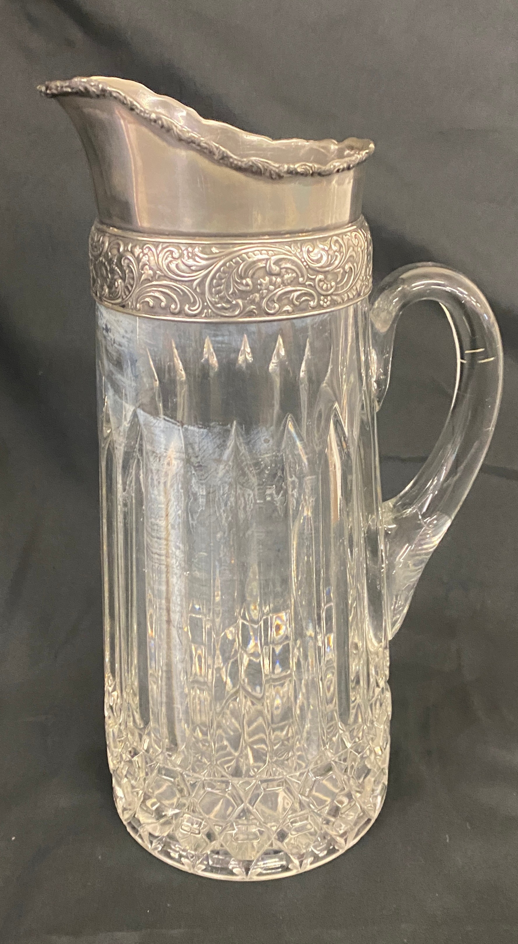 A lead crystal jug with silver plated lid measures approx 11.5 inches tall