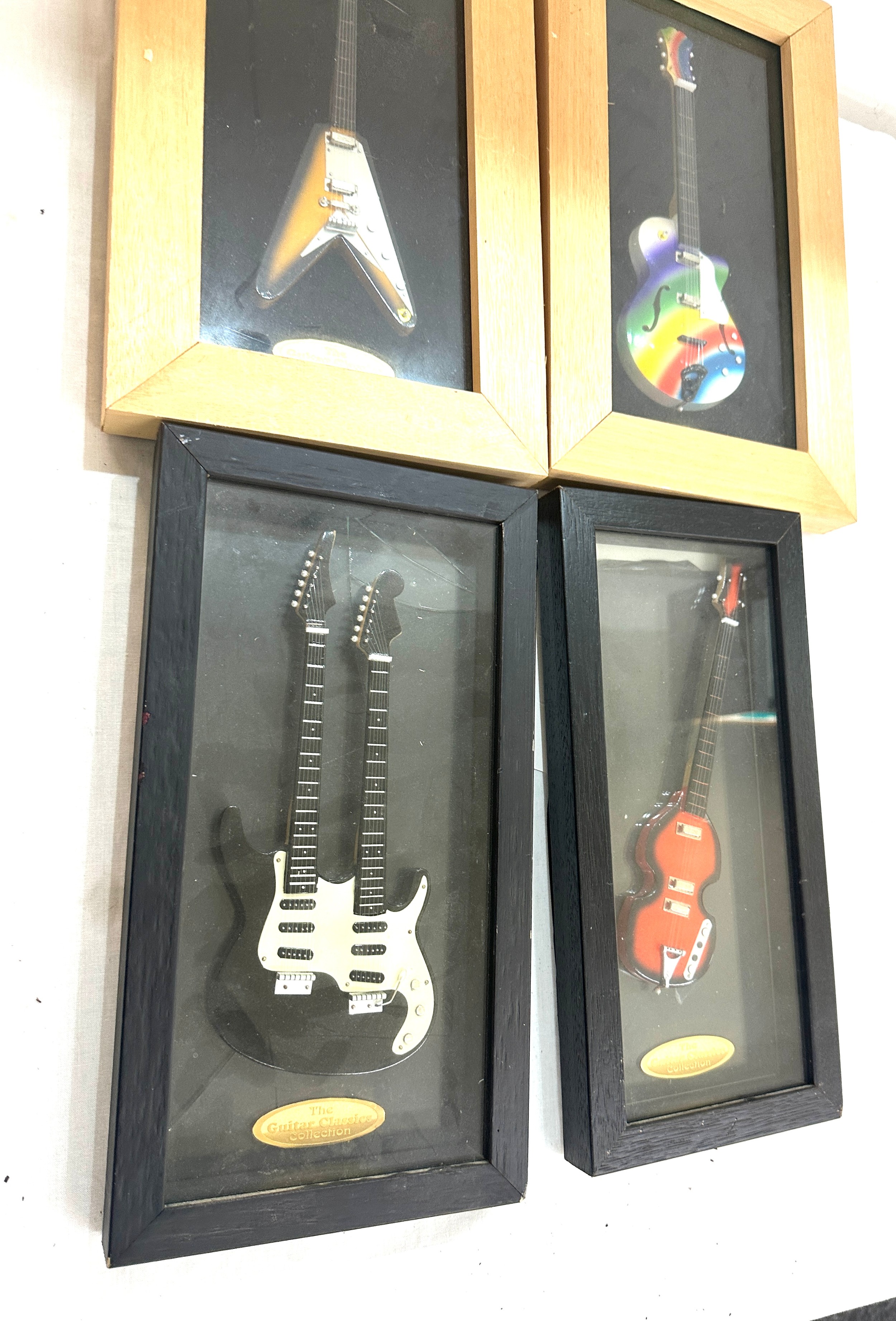 Four framed guitar models two from the Classic guitar collection tallest measures 14 inches