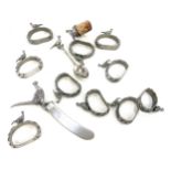 Collection of pewter serviette rings, butter knifes, bottle stopper etc