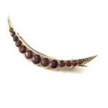Yellow metal possibly gold antique garnet crescent brooch length approx 4.9 cm and weighs approx 3.4