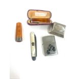 Two amber cheroot/ cigar holder and a zippo lighter and silver fruit knife