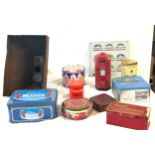 A collection of advertising tins with iron dam pipe and a room in and out indicator.