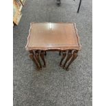 Nest of three glass topped carved tables largest measures 22 inches tall 21.5 inches wide