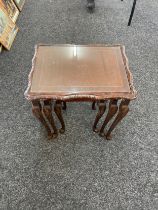 Nest of three glass topped carved tables largest measures 22 inches tall 21.5 inches wide