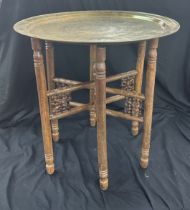 Brass topped wooden folding base table measures approximately 22.5 inches tall 23 inches diameter