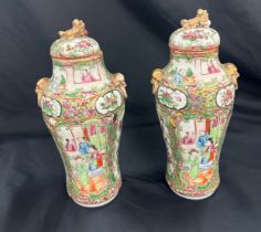 Pair of oriental lidded hand painted vases, no marks to base height 11 inches tall