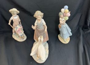 Three Lladro figures includes girl with balloons, girl with geese and boy with wheel barrow of