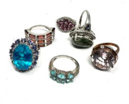Six silver gemstone set dress rings including garnet and tanzanite (36g)
