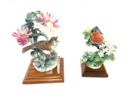 Selection of bird figures on wooden stands, damaged