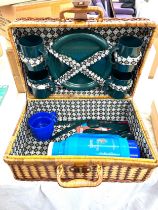 Unused wicker picnic basket set with cups, plates, cutlery and a thermos flask