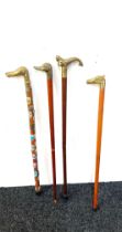 Selection of vintage wooden walking sticks with brass handles includes mermaid, duck, dog and horse