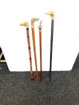 Selection of vintage wooden walking sticks with brass handles includes dogs, horse and duck